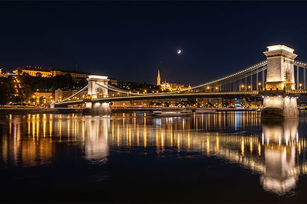 A beautifully lit bridge at night reflecting in the water